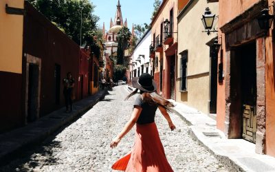 rear-view-woman-standing-footpath-amidst-buildings